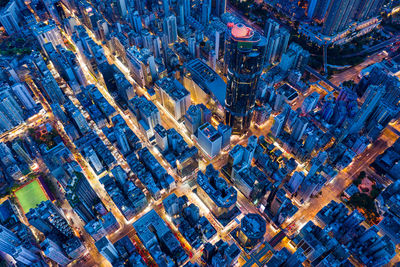 High angle view of illuminated street amidst buildings in city at night