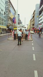 People walking on road along buildings