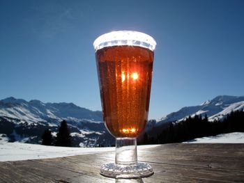 Close-up of beer in glass on table against clear sky