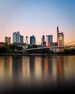 River by buildings against clear sky in city