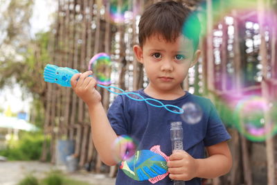 Portrait of cute boy holding bubbles