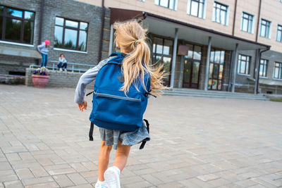 Full length rear view of woman walking in city