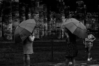 People with umbrella standing on wet rainy day