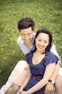 High angle view of smiling couple relaxing on field