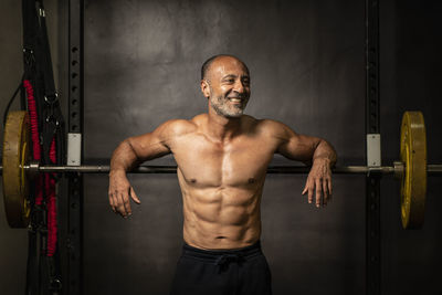 Smiling shirtless man standing in gym