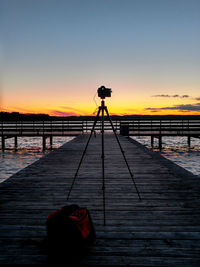 Silhouette of photographing against sky during sunset