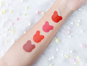 Close-up of woman hand with heart shape on bed