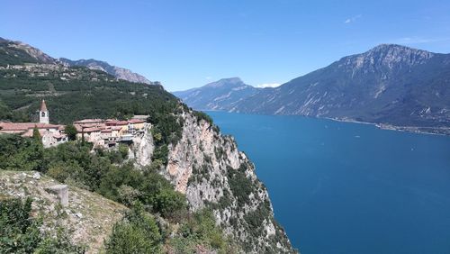 Scenic view of townscape by mountains against clear blue sky