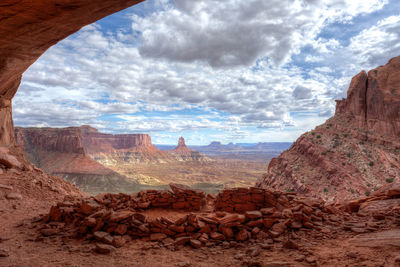 Rock formations in desert against cloudy sky