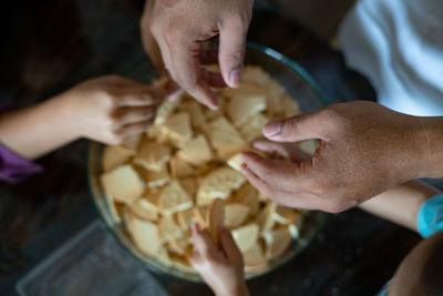 Kids making kek batik or malaysian triple chocolate dessert. crushing the cookies into tiny pieces.