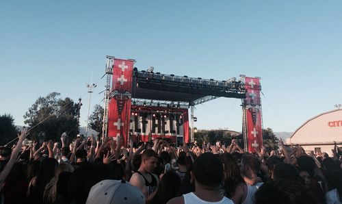 Crowd at music concert against clear sky