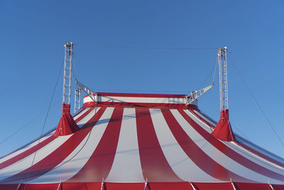 Low angle view of circus tent against clear blue sky