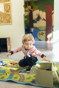 Boy removing toys from box in kindergarten