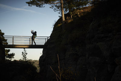 Low angle view of man on tree against sky