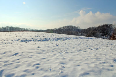 Scenic view of snow covered land against sky