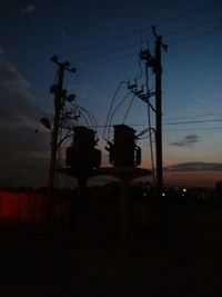 Silhouette of street light against sky at dusk