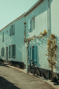 Bicycle by building against clear sky
