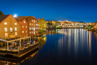 Illuminated buildings by nidelva river at night  in trondheim, norway