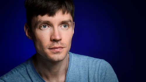 Portrait of young man against blue background