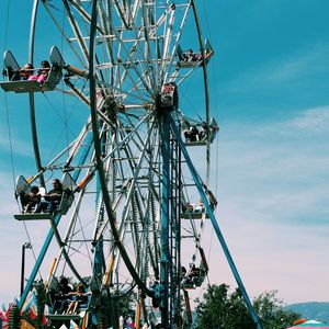 Low angle view of ferris wheel against blue sky