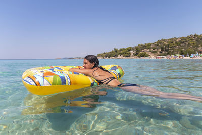 Idyllic summer vacation.a beautiful teen girl in a bikini relaxes in a sea lagoon on an air mattress