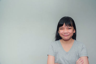 Portrait of smiling mid adult woman against wall