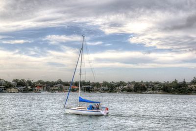 Sailboat moored on sea against sky