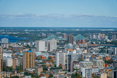 High angle view of city by sea against sky