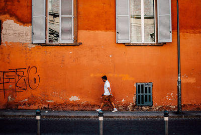 Rear view of man standing by window