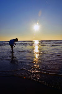 Woman catching clams on the beach