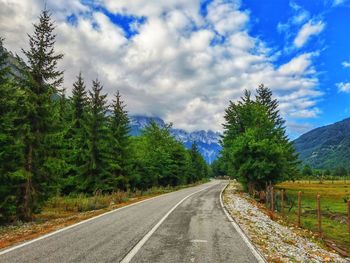 Road amidst trees against sky