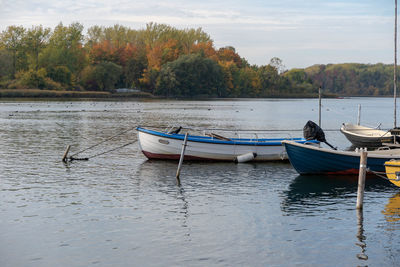 Boats moored in lake against sky