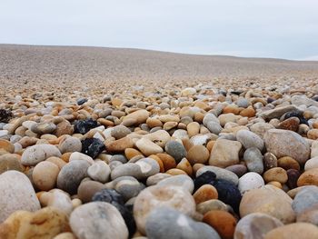 Stones on pebbles at beach against sky