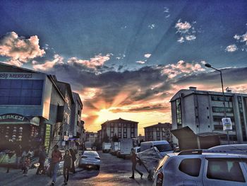 Cars on city against sky during sunset