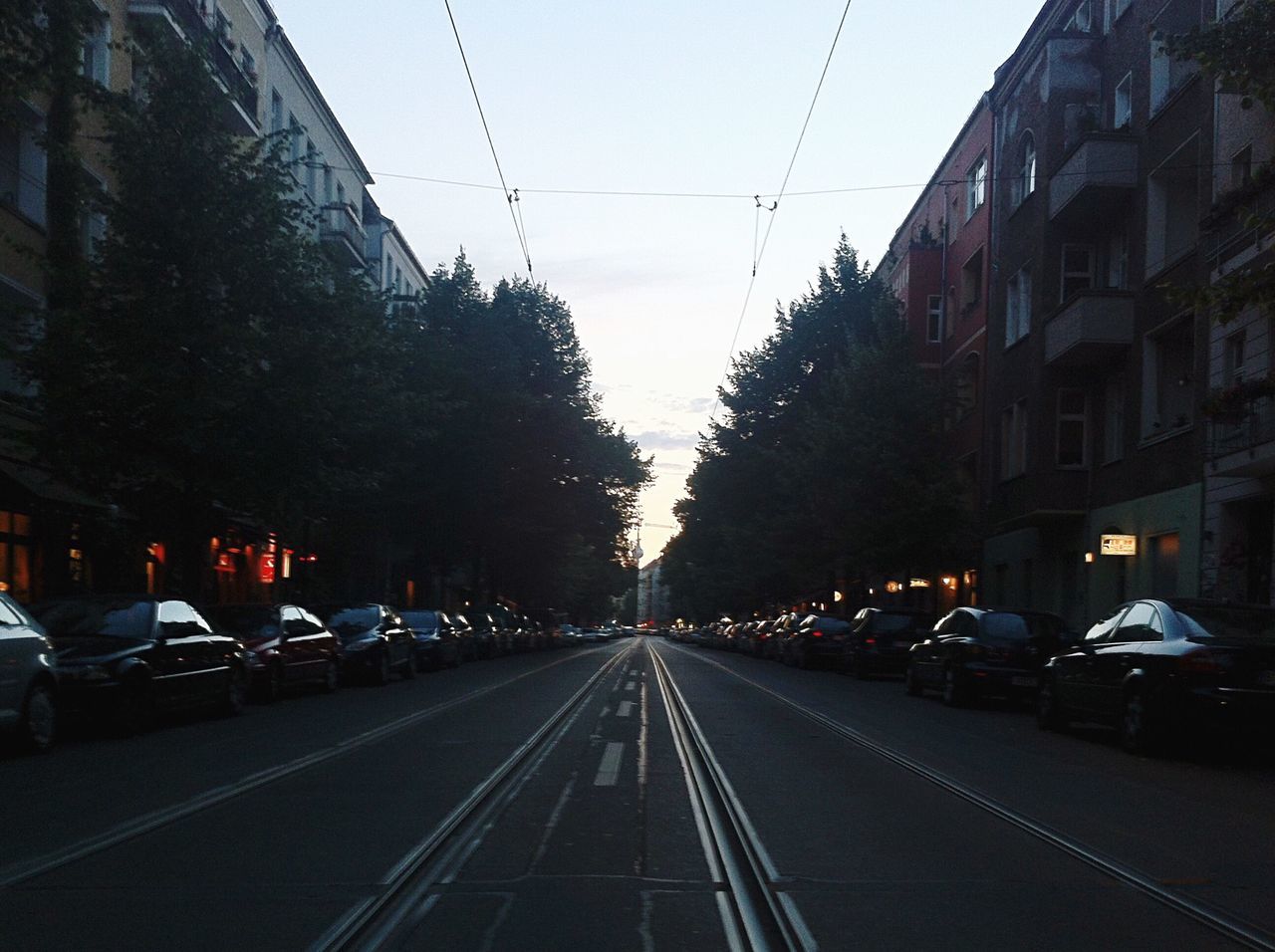 CARS ON ROAD AGAINST SKY IN CITY