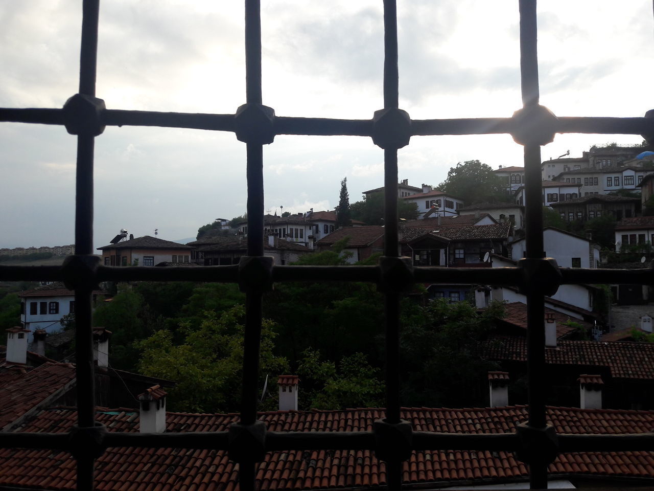 HIGH ANGLE VIEW OF BUILDINGS SEEN THROUGH FENCE