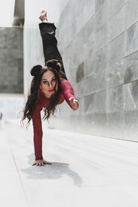 Full length of woman dancing on floor against wall