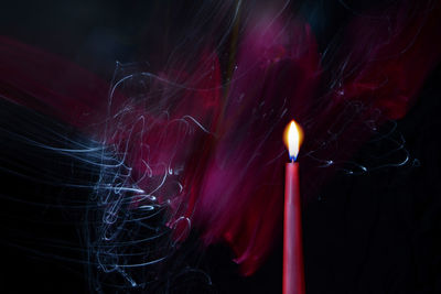 Close-up of illuminated fire against colored backgrounds