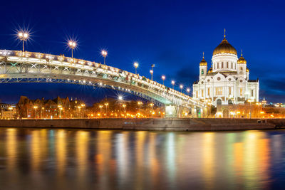 Illuminated bridge over river at night