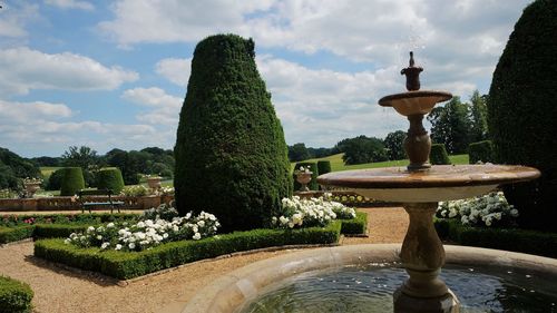 Fountain in garden against sky