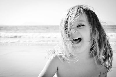 Close-up portrait of cheerful girl at beach during sunny day
