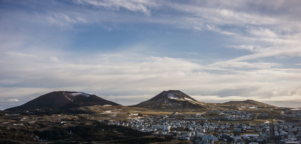 View of cityscape against cloudy sky