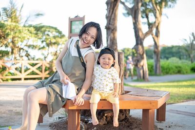 Full length of smiling woman sitting on seat