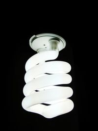 Low angle view of illuminated light bulb against black background