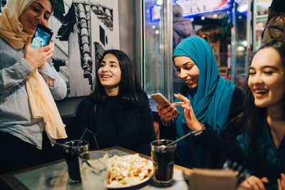 Happy multi-ethnic female friends enjoying at cafe