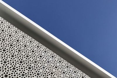 Low angle view of modern building against blue sky