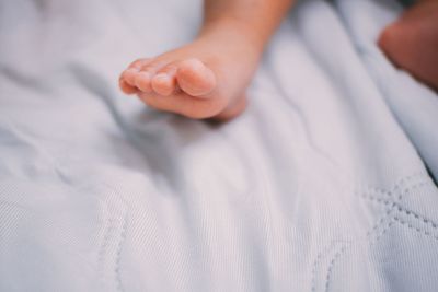 Close-up of baby hand on bed