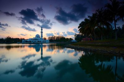 Reflection of mosque on lake against sky during sunset