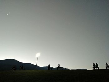 People on field against sky at night