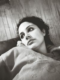 High angle portrait of young woman lying down at home